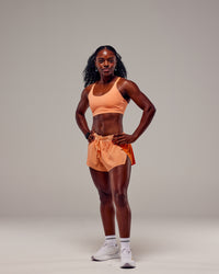 Woman wearing Accelerate 3" Run Shorts - Cantaloupe Colourblock | Thumbnail Index: 2