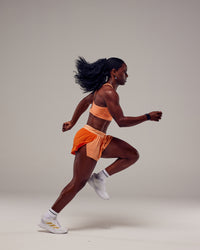 Woman wearing Accelerate 3" Run Shorts - Cantaloupe Colourblock | Thumbnail Index: 1