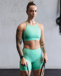 Woman wearing Lift High Neck Sports Bra - Cockatoo | Thumbnail Index: 2