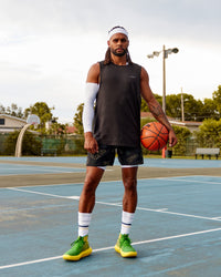Man wearing Patty Mills Challenger 6" Performance Shorts - Black-Vital Green | Thumbnail Index: 1