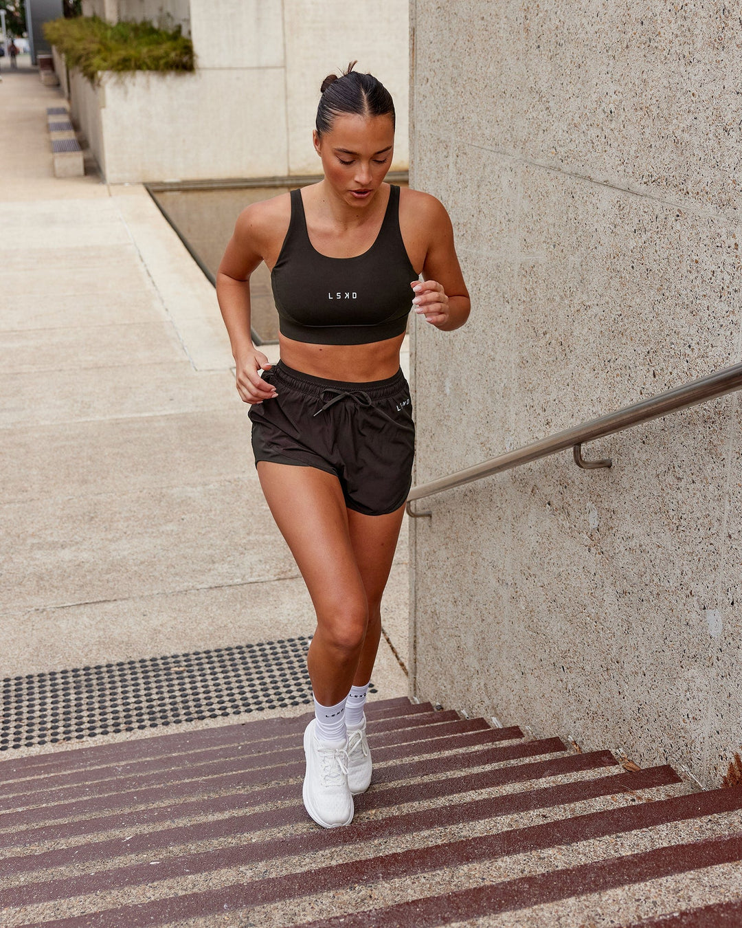 Woman wearing Propel Sports Bra - Dark Walnut - view 4