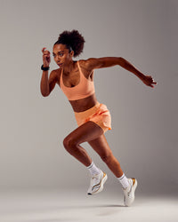 Woman wearing Rapid Sports Bra - Cantaloupe | Thumbnail Index: 0