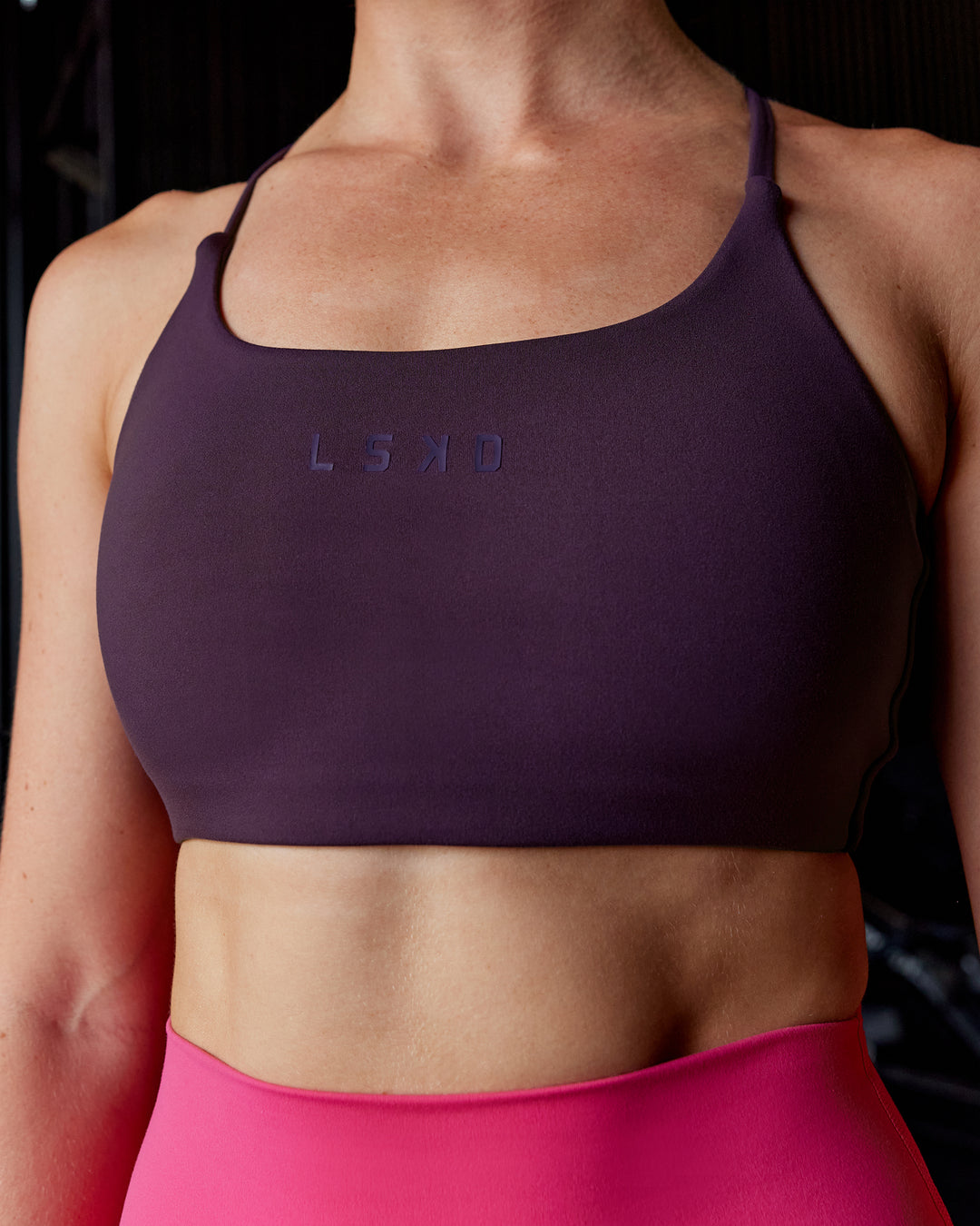 Woman wearing Twist Sports Bra - Midnight Plum - view 1