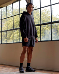 Man wearing Unisex MVP Hoodie Oversize - Black | Thumbnail Index: 2