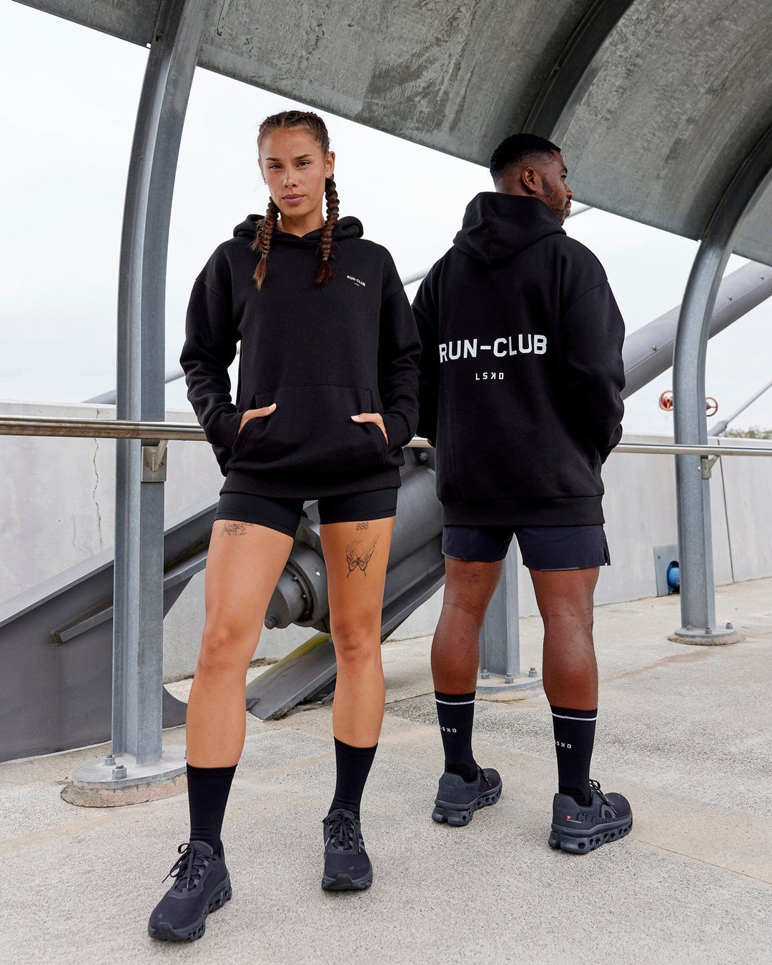 Duo wearing Unisex RUN-CLUB Hoodie Oversize - Black - view 1