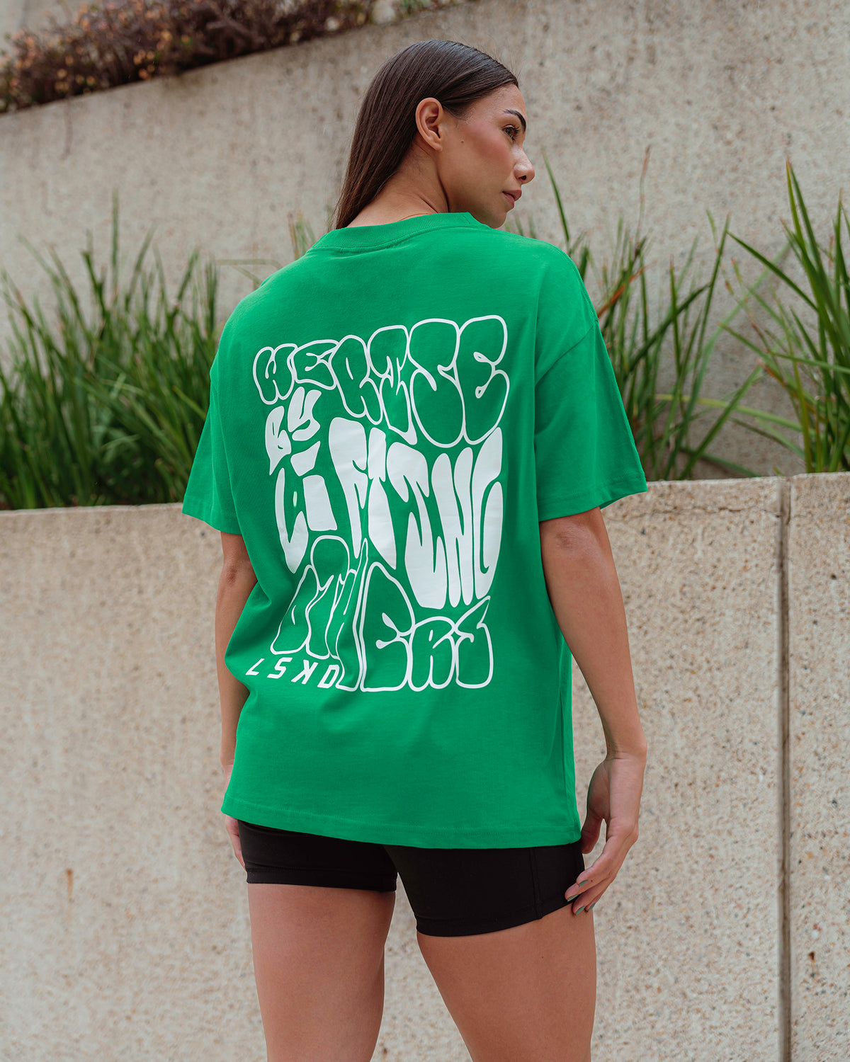 Woman wearing Unisex We Rise Heavyweight Tee Oversize - Impact Green-White