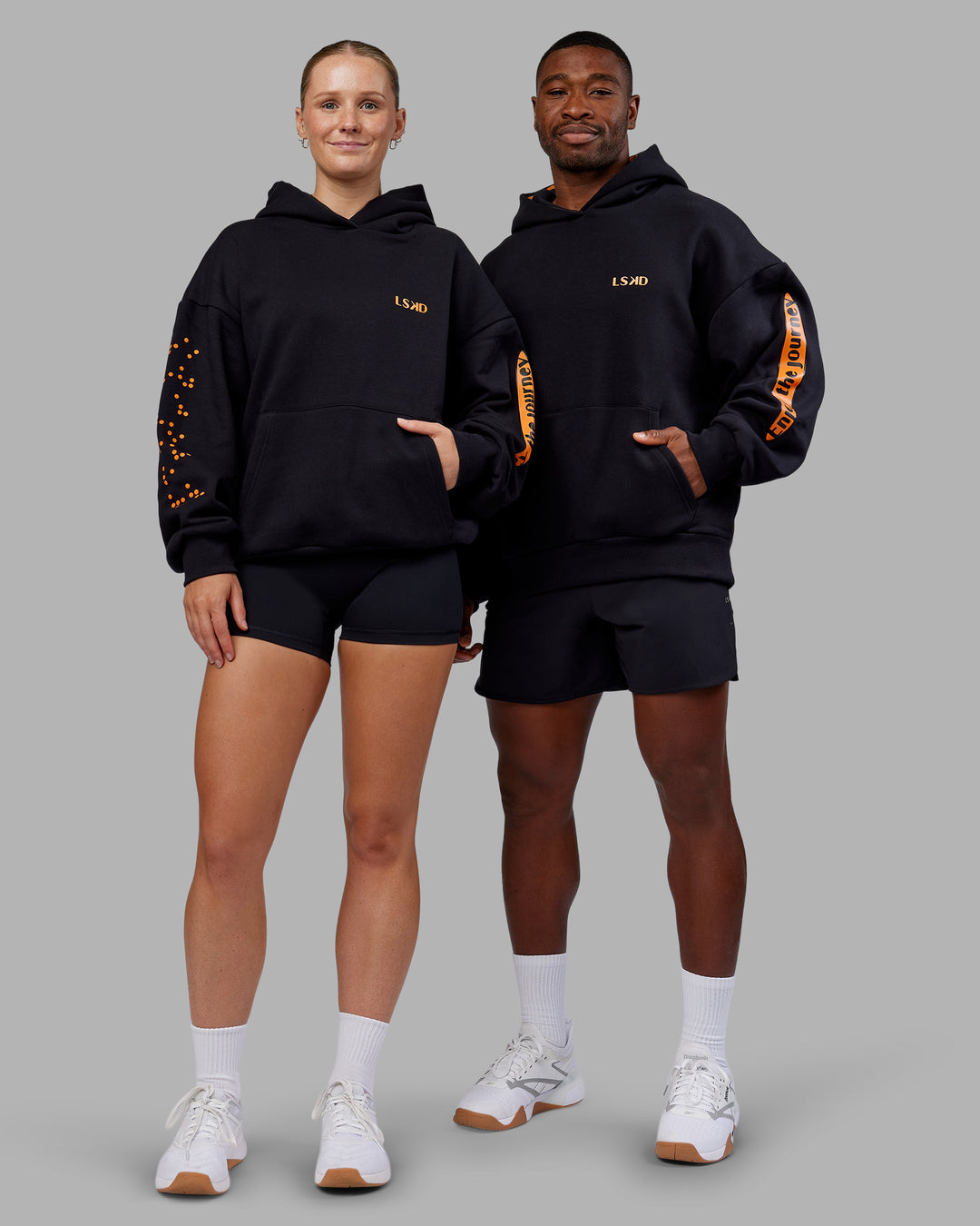 Duo wearing Hyped Unisex Oversized Hoodie - Black-Vibrant Orange | Model:Both | Size:Duo - view 1
