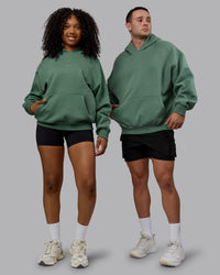 Duo wearing Unisex MVP Hoodie Oversize - Sage Brush | Thumbnail Index: 0