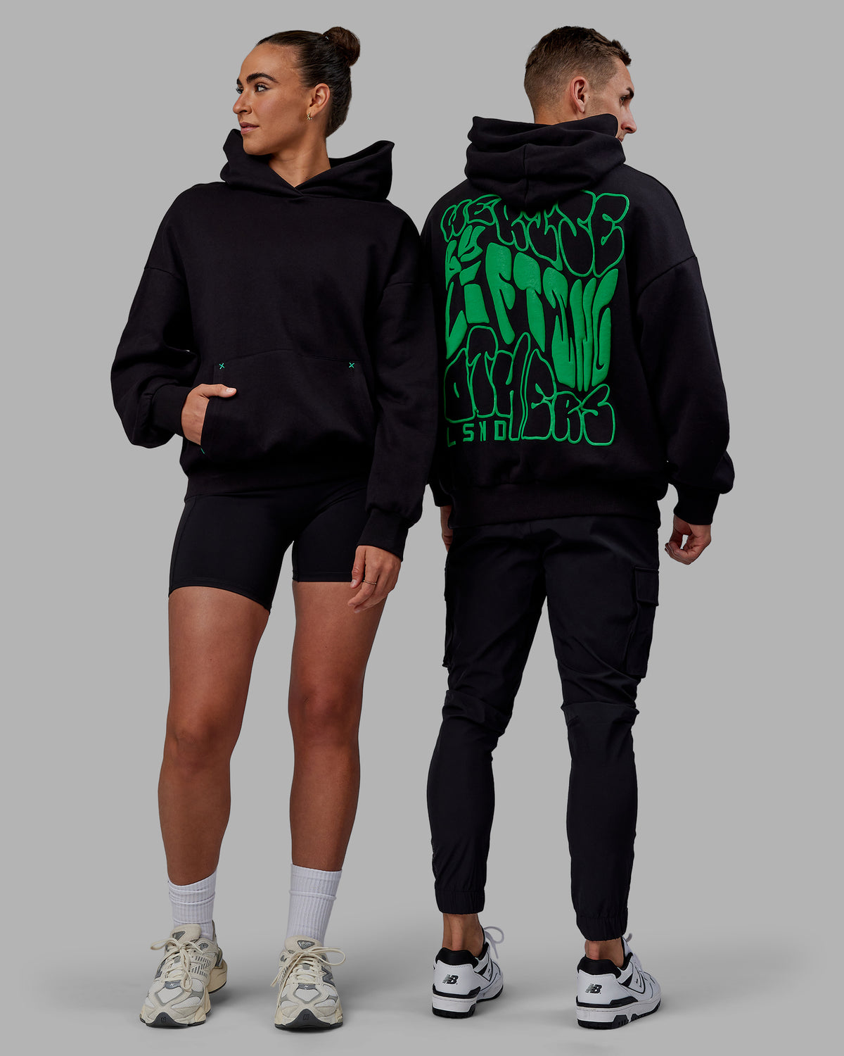 Duo wearing Unisex We Rise Hoodie Oversize - Black-Impact Green