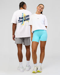 Duo wearing Woman wearing Woman wearing Run Like The Wind FLXCotton Oversized Tee - White-Future Navy | Model:Grace | Size:S | Model:Malebo | Size:M | Thumbnail Index: 1