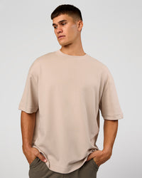 Man wearing AfterDark ZeroCrease Oversized Tee - Shale Beige | Model:Jackson | Size:L | Thumbnail Index: 1