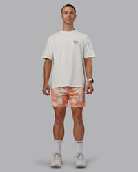 Man wearing Grand Slam 6" Shorts in Wildflower Cantaloupe | Size:L | Thumbnail Index: 1