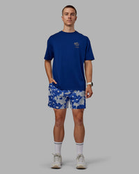 Man wearing Grand Slam 6" Shorts in Wildflower Midnight Blue | Size:L | Thumbnail Index: 1