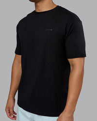 Man wearing RUN CLUB FLXCotton Tee Oversize - Black-Reflective | Model:Kaelyb | Size:L | Thumbnail Index: 7