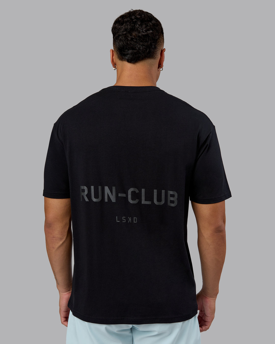 Man wearing RUN CLUB FLXCotton Tee Oversize - Black-Reflective | Model:Kaelyb | Size:L - view 7