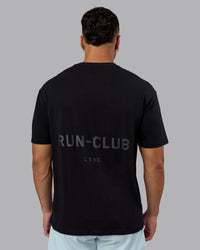 Man wearing RUN CLUB FLXCotton Tee Oversize - Black-Reflective | Model:Kaelyb | Size:L | Thumbnail Index: 6