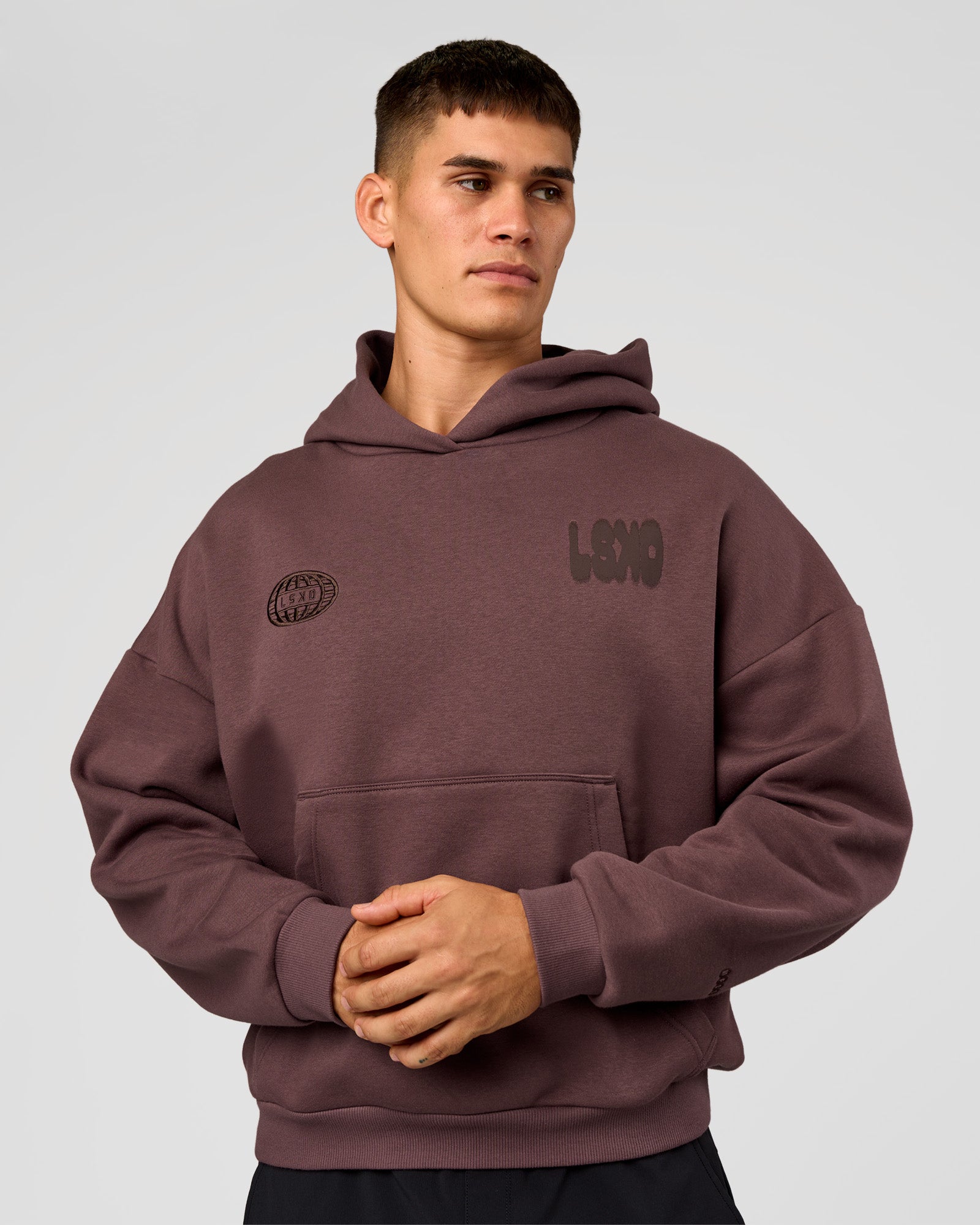 Man wearing Static Grit Unisex Boxy Hoodie - Cocoa Powder-Hot Chocolate | Model:Jackson | Size:L