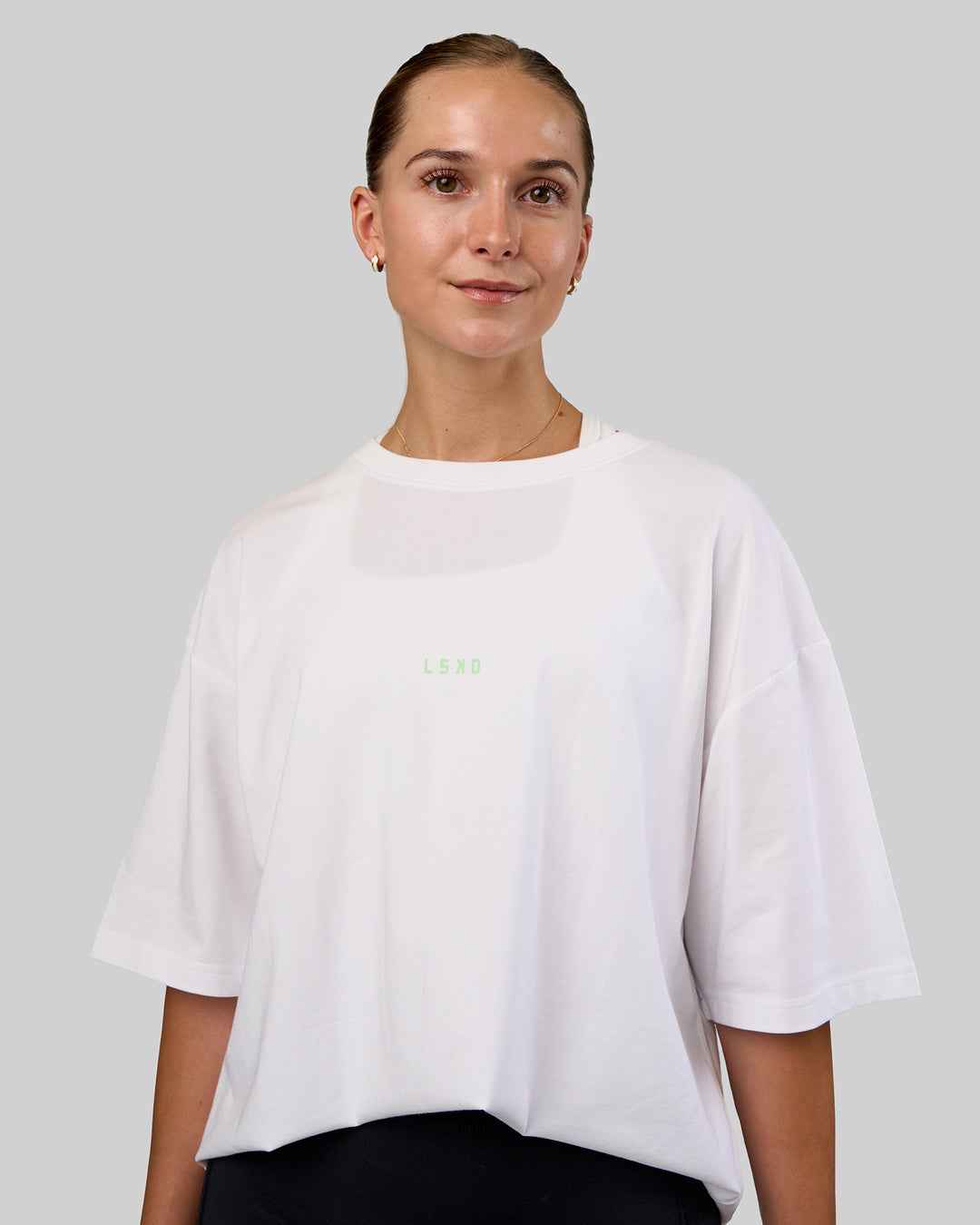 Woman wearing Together We Rise FLXCotton Oversized Tee - White-Solar Lime | Model:Myrte | Size:L - view 4