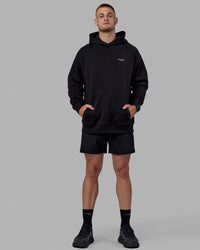 Man wearing Unisex RUN-CLUB Hoodie Oversize - Black | Thumbnail Index: 4
