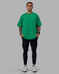Man wearing Unisex We Rise Heavyweight Tee Oversize - Impact Green-White | Thumbnail Index: 9