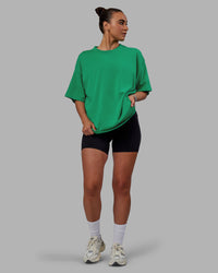 Woman wearing Unisex We Rise Heavyweight Tee Oversize - Impact Green-White | Thumbnail Index: 10