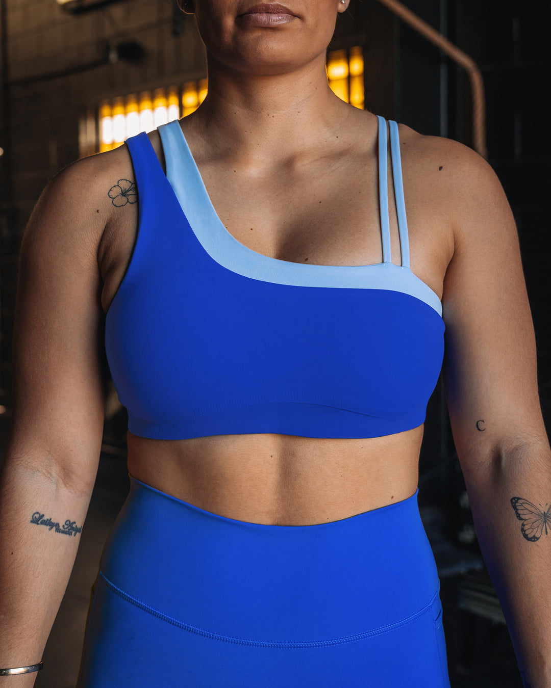 Woman wearing Thrive Asymmetric Sports Bra - Power Cobalt-Open Air | Model:Tiare | Size:M - view 5