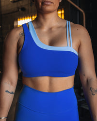 Woman wearing Thrive Asymmetric Sports Bra - Power Cobalt-Open Air | Model:Tiare | Size:M | Thumbnail Index: 4