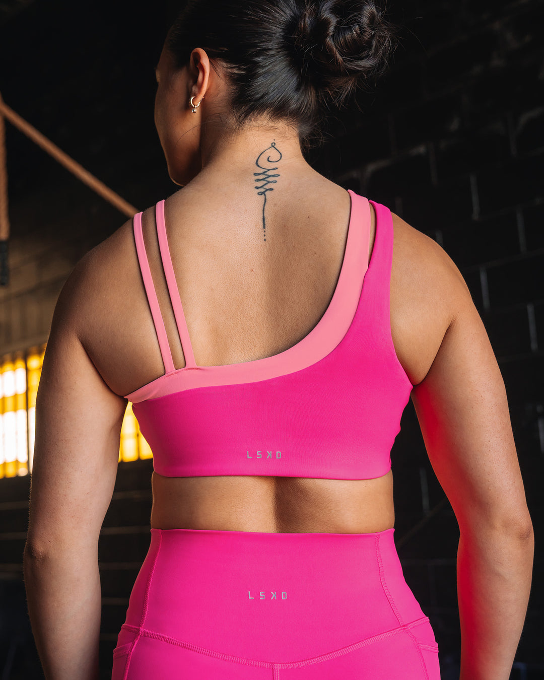 Woman wearing Thrive Asymmetric Sports Bra - Ultra Pink-Candy Pink | Model:Teraipine | Size:M - view 9
