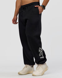 Man wearing Static Grit Baggy Track Pant - Black-Alloy | Model:Jaiden | Size:M | Thumbnail Index: 0