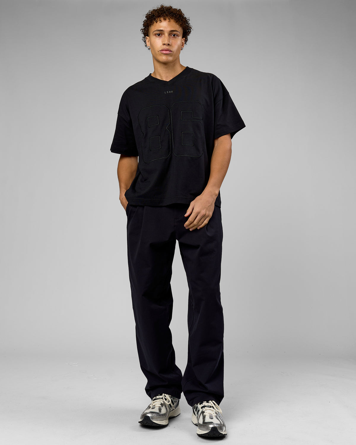 Man wearing 86 V-Neck Oversized Tee - Black-Black | Model:Leandro | Size:M