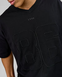 Man wearing 86 V-Neck Oversized Tee - Black-Black | Model:Leandro | Size:M | Thumbnail Index: 2