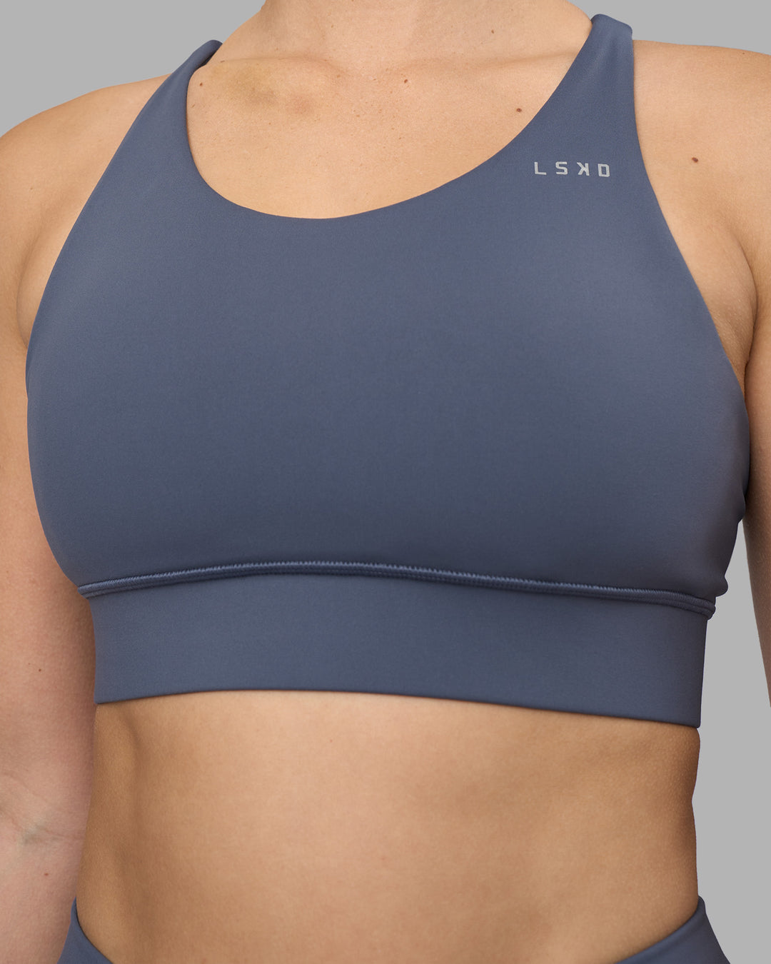 Woman wearing Accelerate Sports Bra - Night Shadow | Set:true | Angle:closeup | Model:Amy | Size:M - view 4