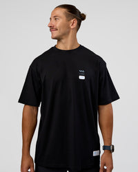 Man wearing Archive FLXCotton Oversized Tee - Black-Open Air | Model:Jaiden | Size:M | Thumbnail Index: 2