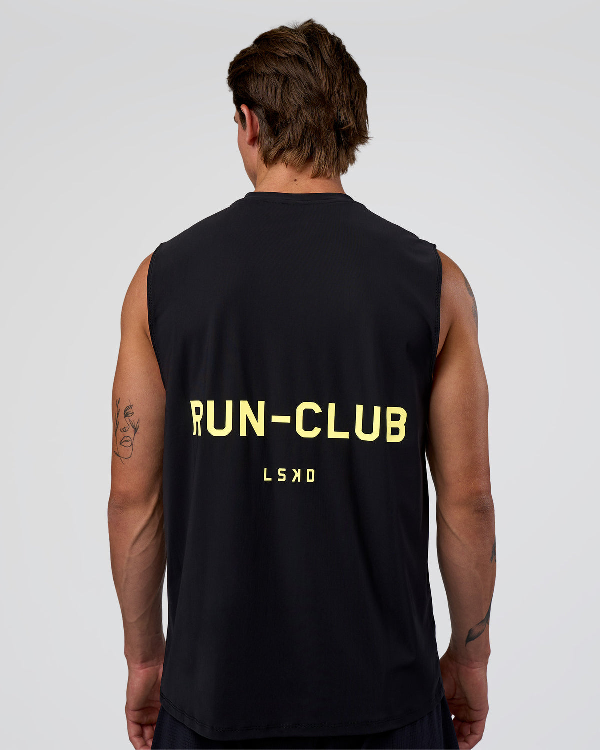 Man wearing Cadence RUN CLUB Muscle Tank - Black-Yellow Fizz | Model:Konnor | Size:M