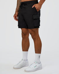 Man wearing Energy Stretch 6" Performance Cargo Short - Black | Model:Daarian | Size:M | Thumbnail Index: 0