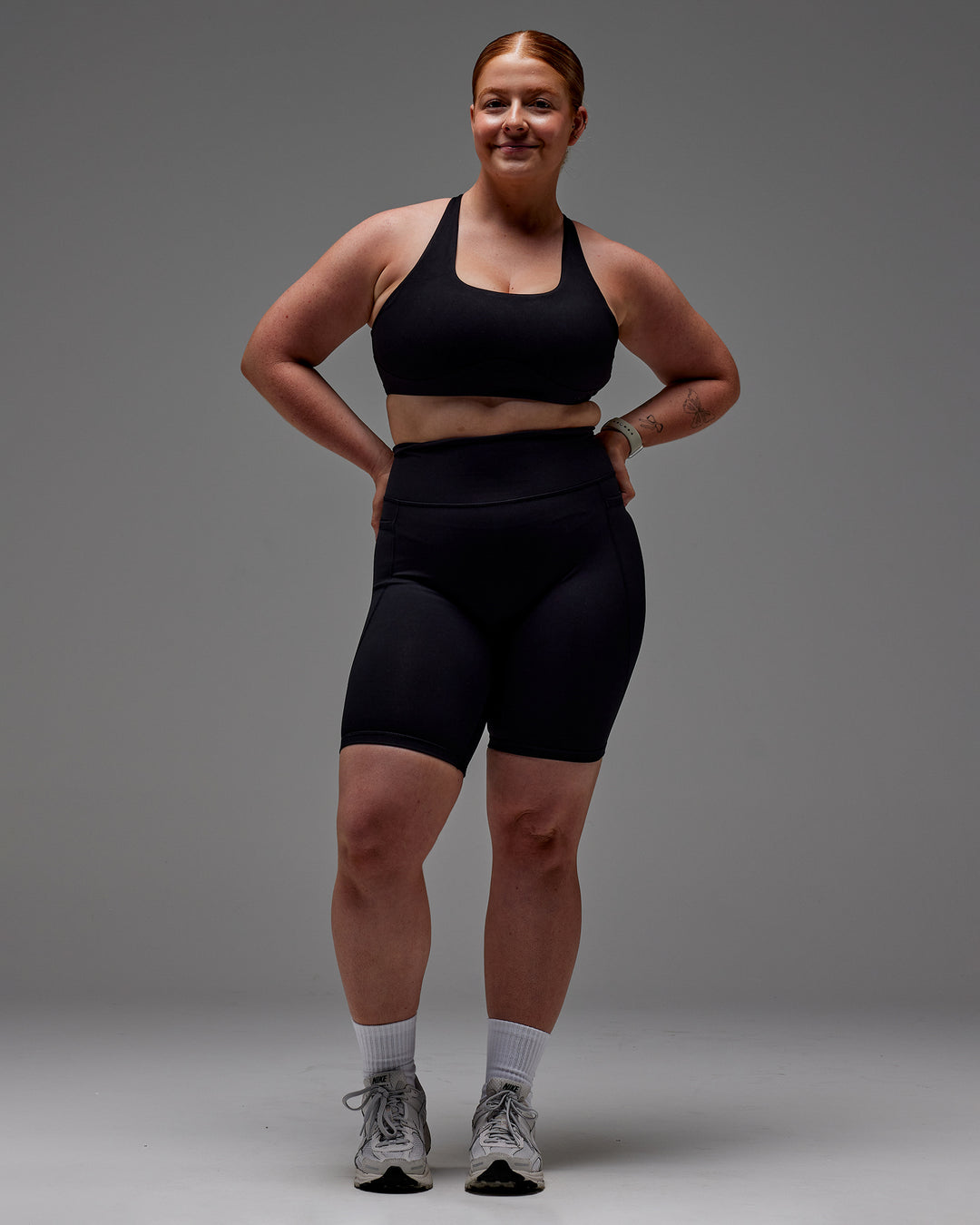 Woman wearing Fusion Ultra High-Rise 9" Short Pockets - Black | Model:Caity | Size:M - view 24