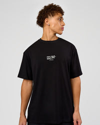 Man wearing Run Club Script FLXCotton Oversized Tee - Black-Alloy | Model:Leandro | Size:M | Thumbnail Index: 1