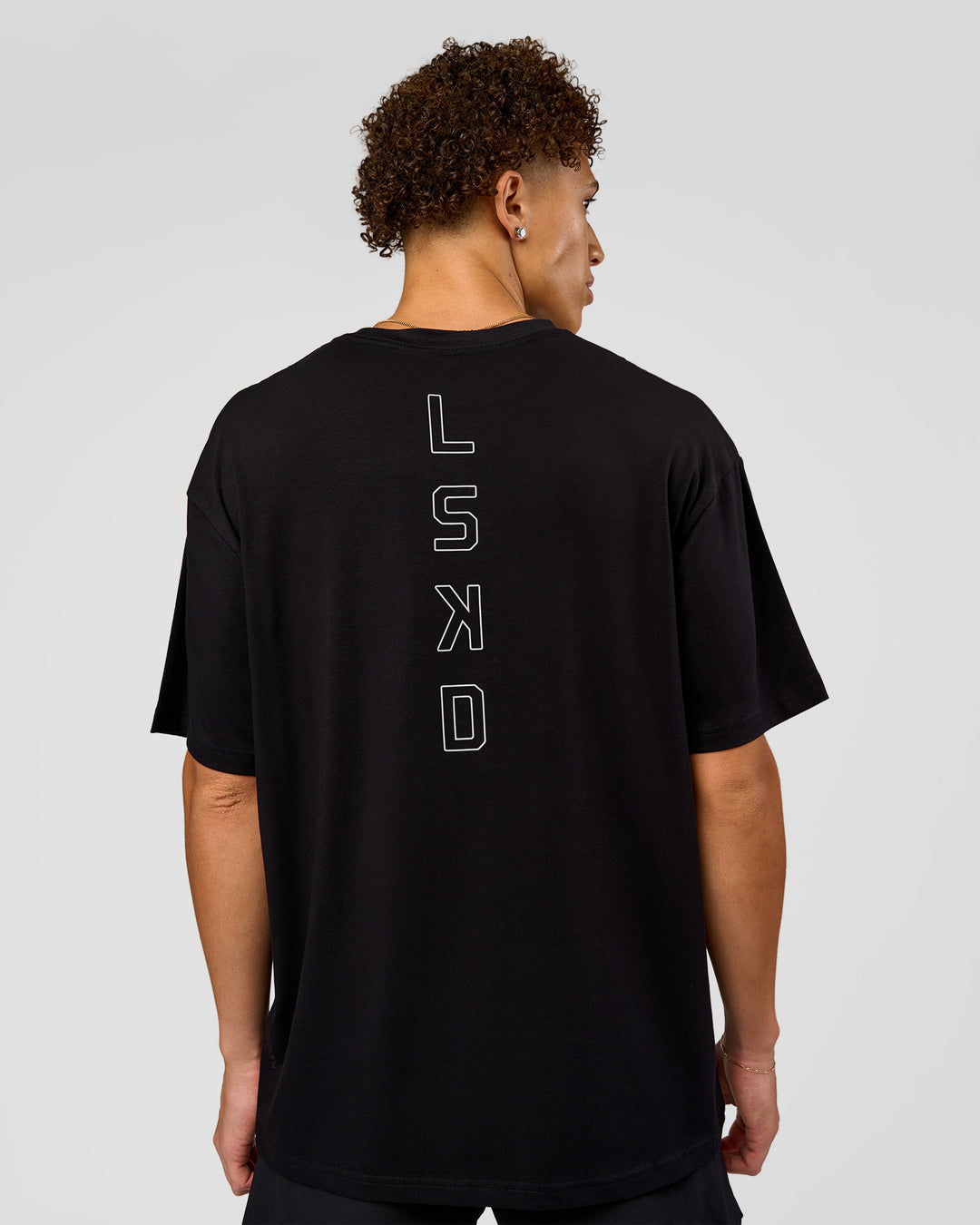 Man wearing Run Club Script FLXCotton Oversized Tee - Black-Alloy | Model:Leandro | Size:M - view 3