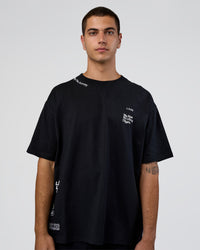 Man wearing Sticker Heavyweight Oversized Tee - Black-White | Model:Zoran | Size:M | Thumbnail Index: 1