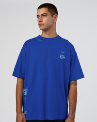 Man wearing Sticker Heavyweight Oversized Tee - Electric Indigo-Baltic Sea | Model:Zoran | Size:M | Thumbnail Index: 1