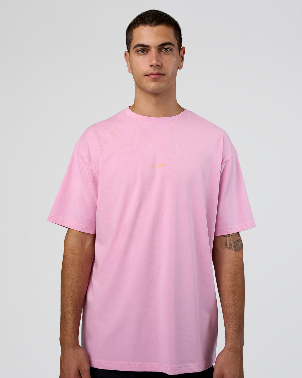 Man wearing Together We Rise FLXCotton Oversized Tee - Bubblegum-Warm Apricot | Model:Zoran | Size:L