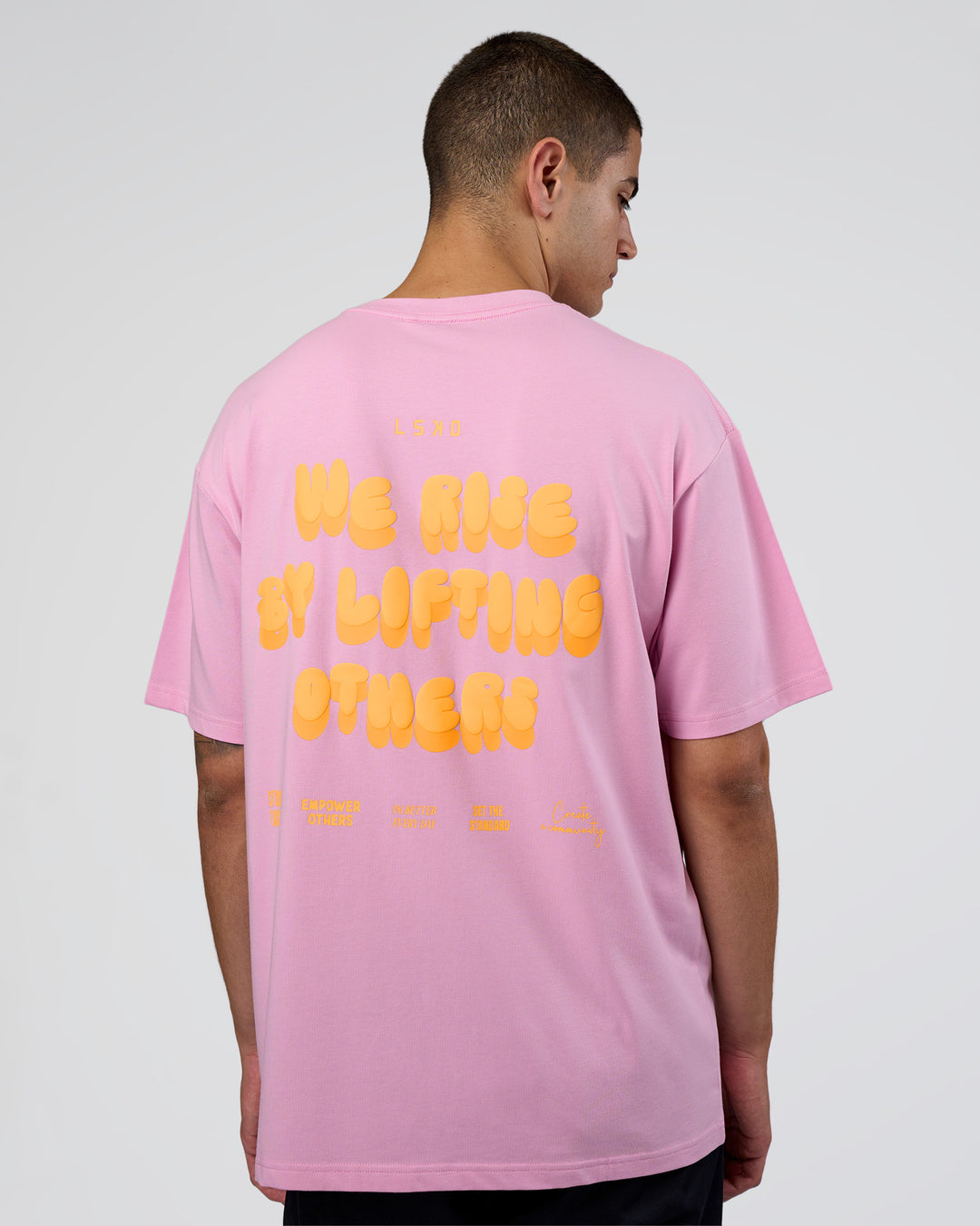 Man wearing Together We Rise FLXCotton Oversized Tee - Bubblegum-Warm Apricot | Model:Zoran | Size:L - view 1