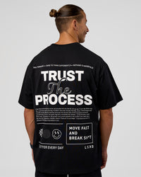 Man wearing Trust The Process Heavyweight Unisex Oversized Tee - Black-White | Model:Jaiden | Size:M | Thumbnail Index: 1