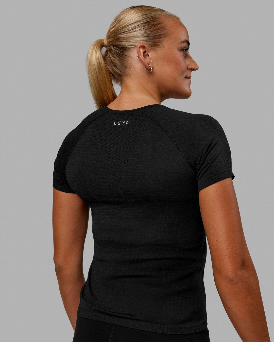 Woman wearing AeroFLX+ Seamless Tee - Black Marl - view 4