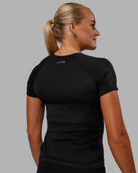 Woman wearing AeroFLX+ Seamless Tee - Black Marl | Thumbnail Index: 3