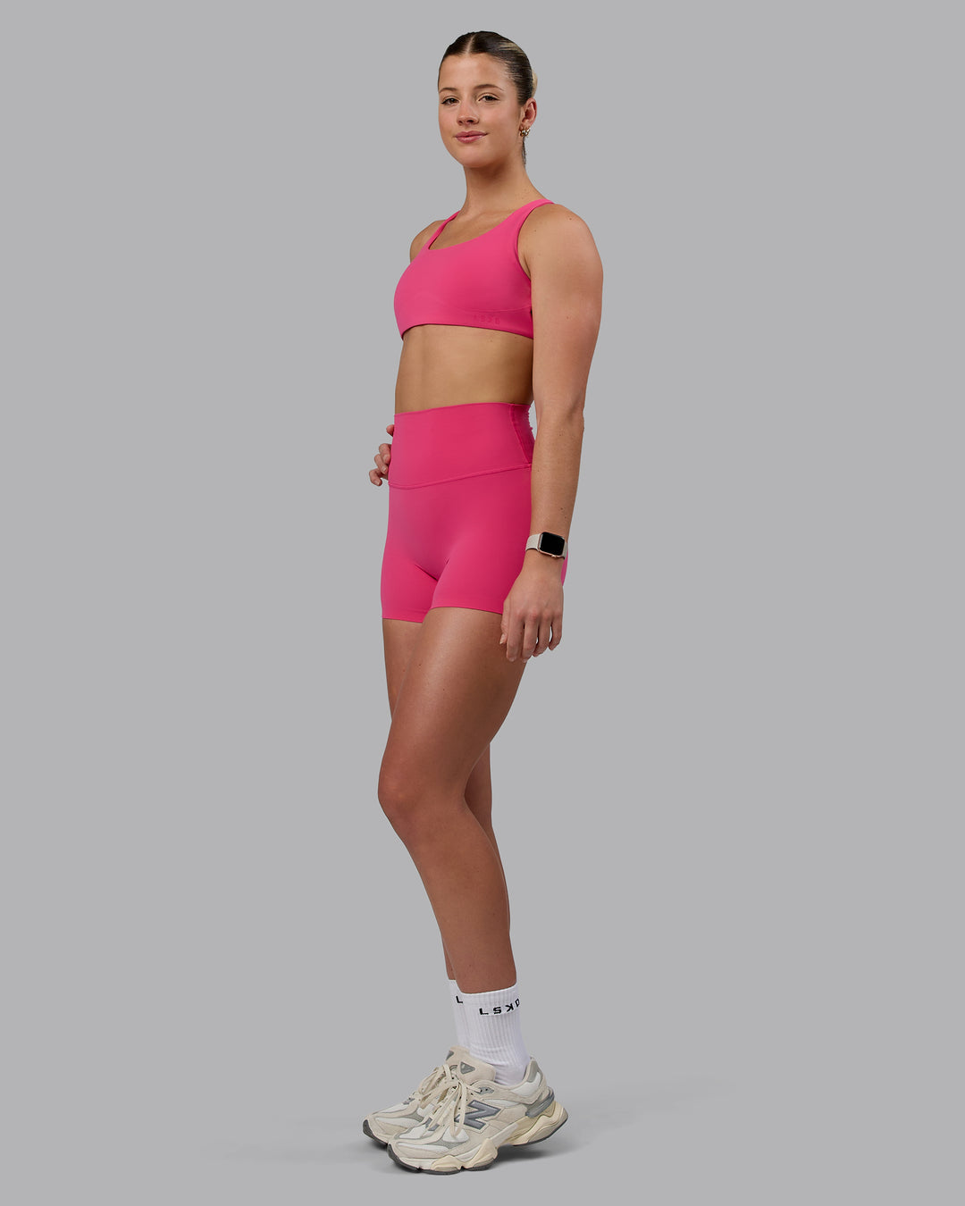 Woman wearing Aspire Sports Bra - Pink Flash - view 4