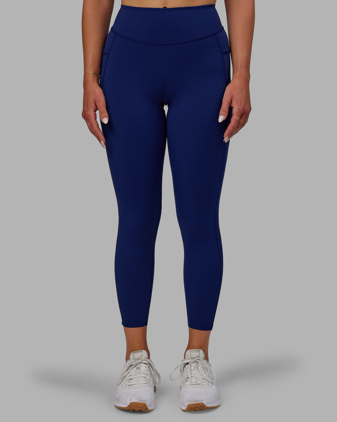 Woman wearing Elite High-Rise 7/8 Legging Pockets - Midnight Blue - view 1