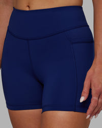 Woman wearing Elite High-Rise 4" Short Pockets - Midnight Blue | Thumbnail Index: 0