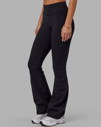 Woman wearing Fusion Ultra High-Rise Flared Legging Pockets - Black | Model:Milly | Size:S | Thumbnail Index: 5