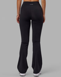 Woman wearing Fusion Ultra High-Rise Flared Legging Pockets - Black | Model:Milly | Size:S | Thumbnail Index: 3